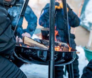 Pause autour d’un feu de camp en Laponie suédoise, cuisine en plein air et expérience nordique lors d’un voyage hivernal