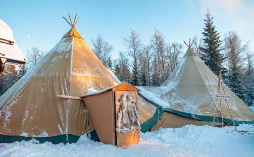 Tente traditionnelle chauffée dans un campement enneigé près de Luleå en Laponie suédoise, expérience immersive dans le Grand Nord.