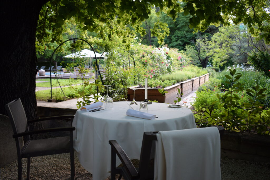 terrasse gastronomique du Prieuré Baumanière dans un jardin verdoyant en Provence
