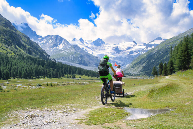 Cyclistes en pleine nature dans les Alpes, voyage à vélo entre montagne et paysages panoramiques