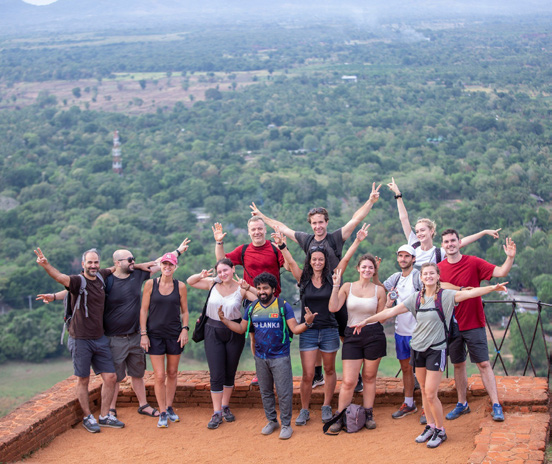 Groupe de voyageurs en randonnée posant sur un point de vue avec vue panoramique