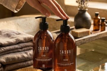 Soins Terre de Mars en flacons ambrés dans une salle de bain naturelle avec serviettes, brosse et lumière douce.