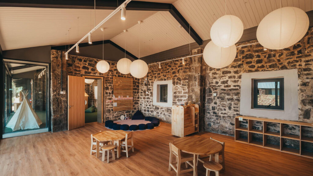 Salle de classe de HEI Schools Mauritius avec mobilier en bois et suspensions lumineuses