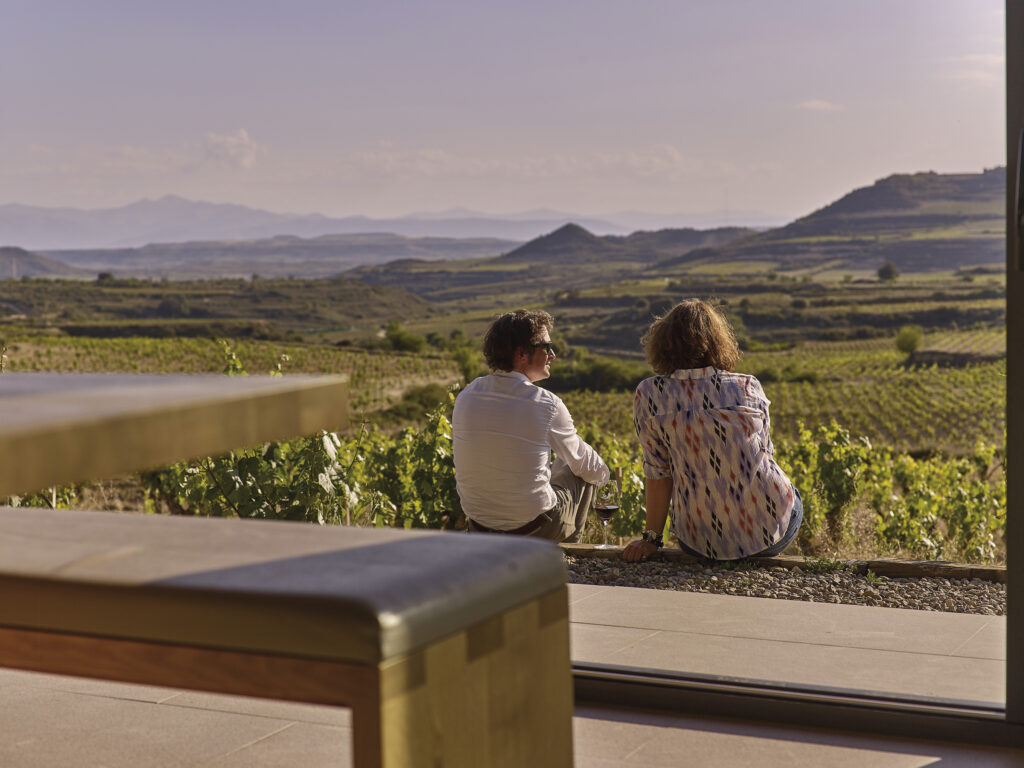 Couple dégustant un verre de vin avec vue panoramique sur les vignes de Rioja Alavesa