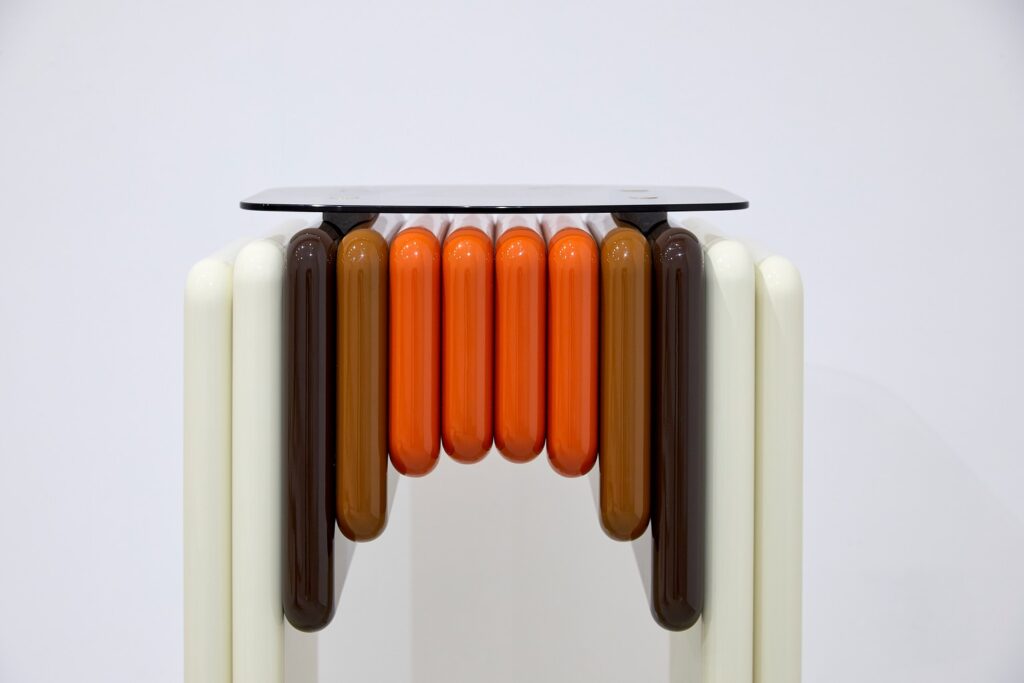 Radiateur design aux éléments cylindriques orange et brun, pièce présentée à Maison&Objet