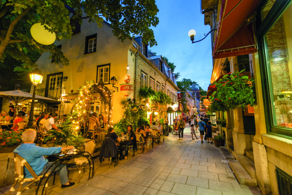 Rue du Petit-Champlain illuminée le soir, terrasses animées dans le Vieux-Québec