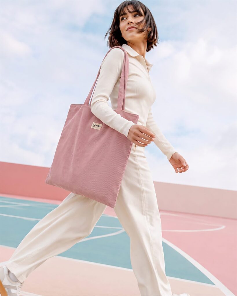 Le tote bag rose Akinod porté à l'épaule, opération Octobre Rose