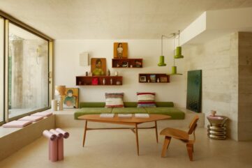 Salon d'une maison d'architecte du Roucas-Blanc à Marseille, banquette verte, béton brut et baie vitrée sur le jardin