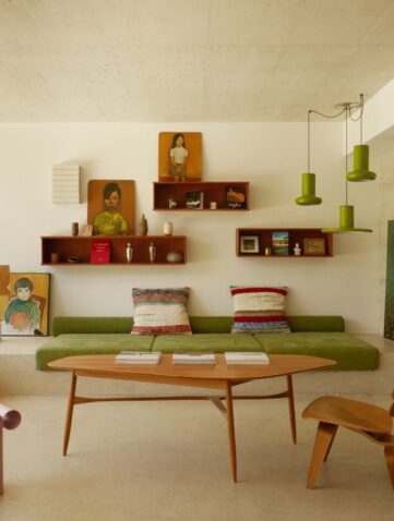 Salon d'une maison d'architecte du Roucas-Blanc à Marseille, banquette verte, béton brut et baie vitrée sur le jardin