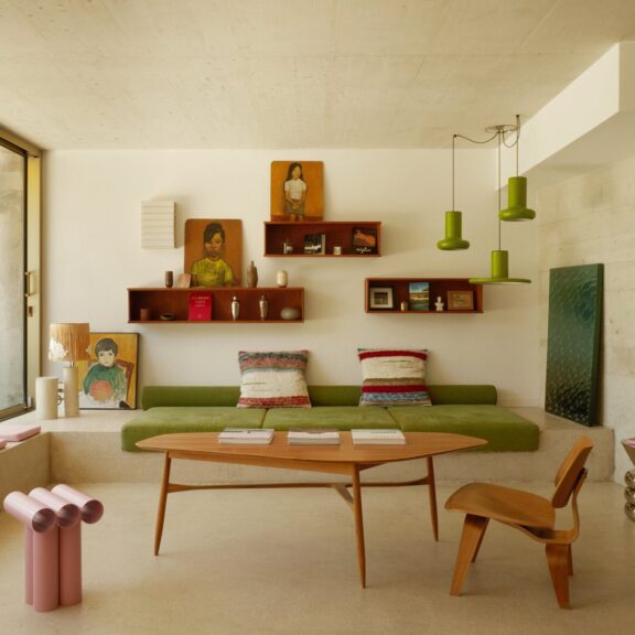 Salon d'une maison d'architecte du Roucas-Blanc à Marseille, banquette verte, béton brut et baie vitrée sur le jardin
