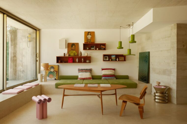 Salon d'une maison d'architecte du Roucas-Blanc à Marseille, banquette verte, béton brut et baie vitrée sur le jardin