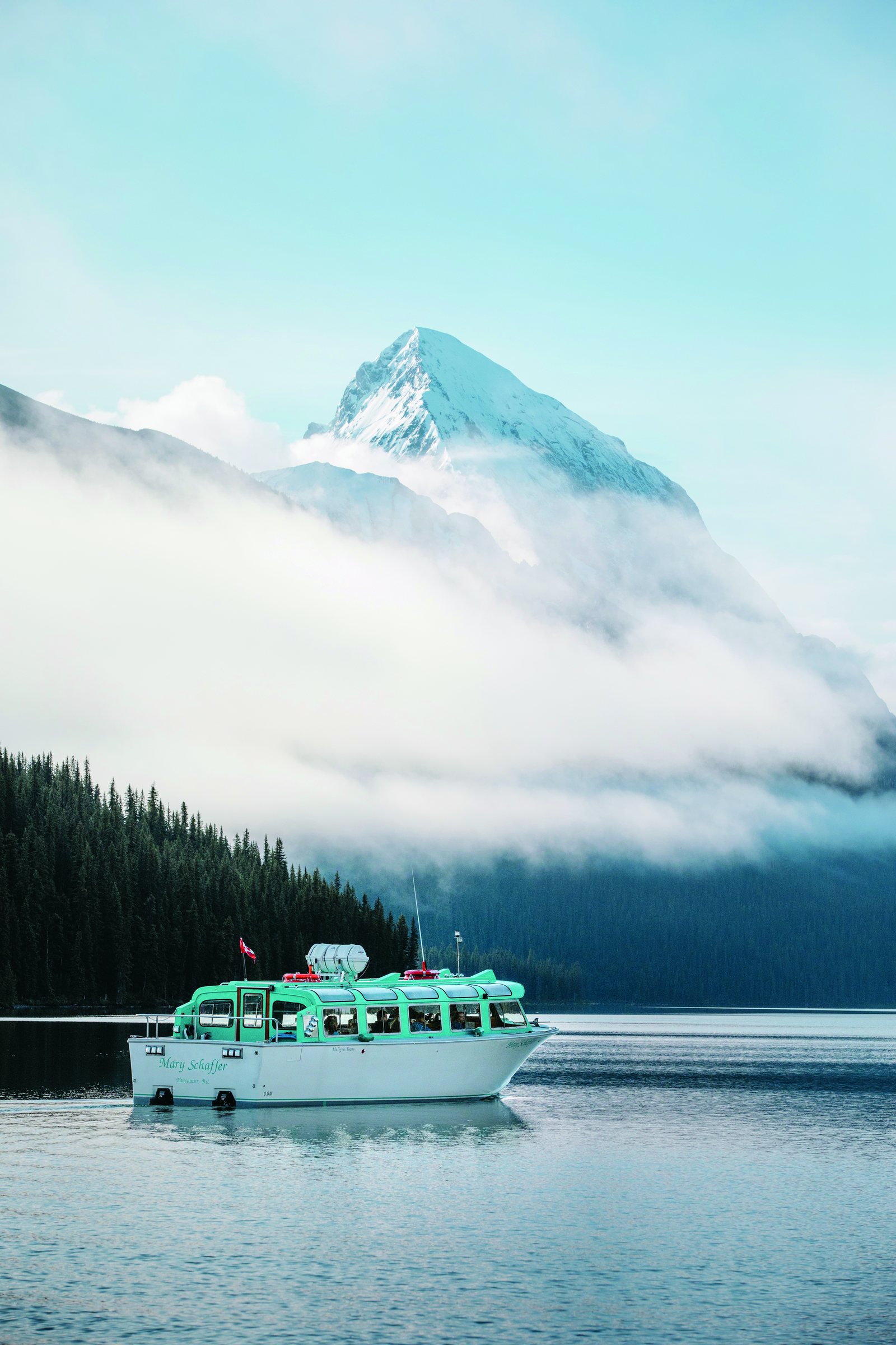 Bateau de croisière sur le lac Maligne, montagnes dans la brume
