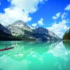 Canoë rouge sur les eaux turquoise du lac Maligne, sous des sommets enneigés, dans le parc national de Jasper