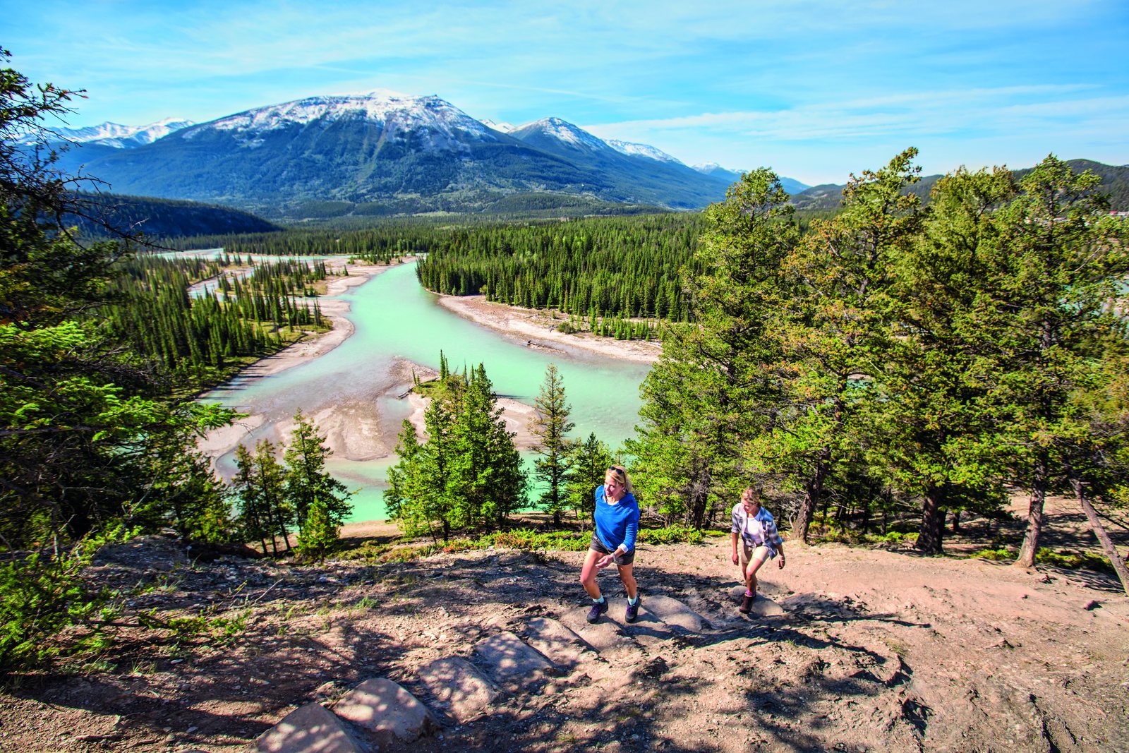 Deux randonneurs assis au promontoire d'Old Fort Point, la rivière Athabasca turquoise en contrebas