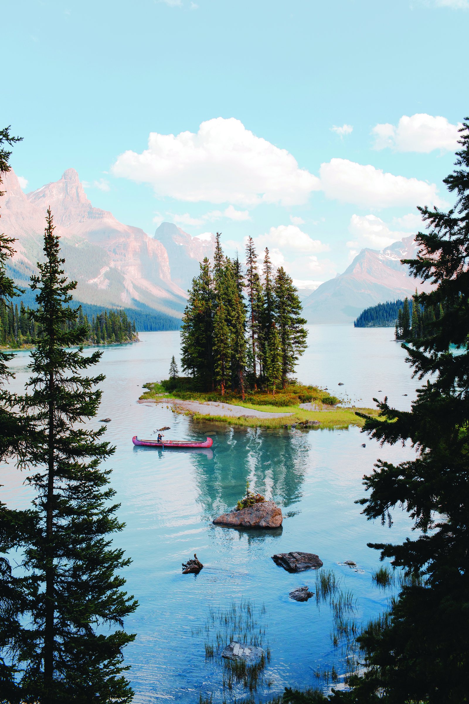 Spirit Island, petite île boisée du lac Maligne, devant des montagnes