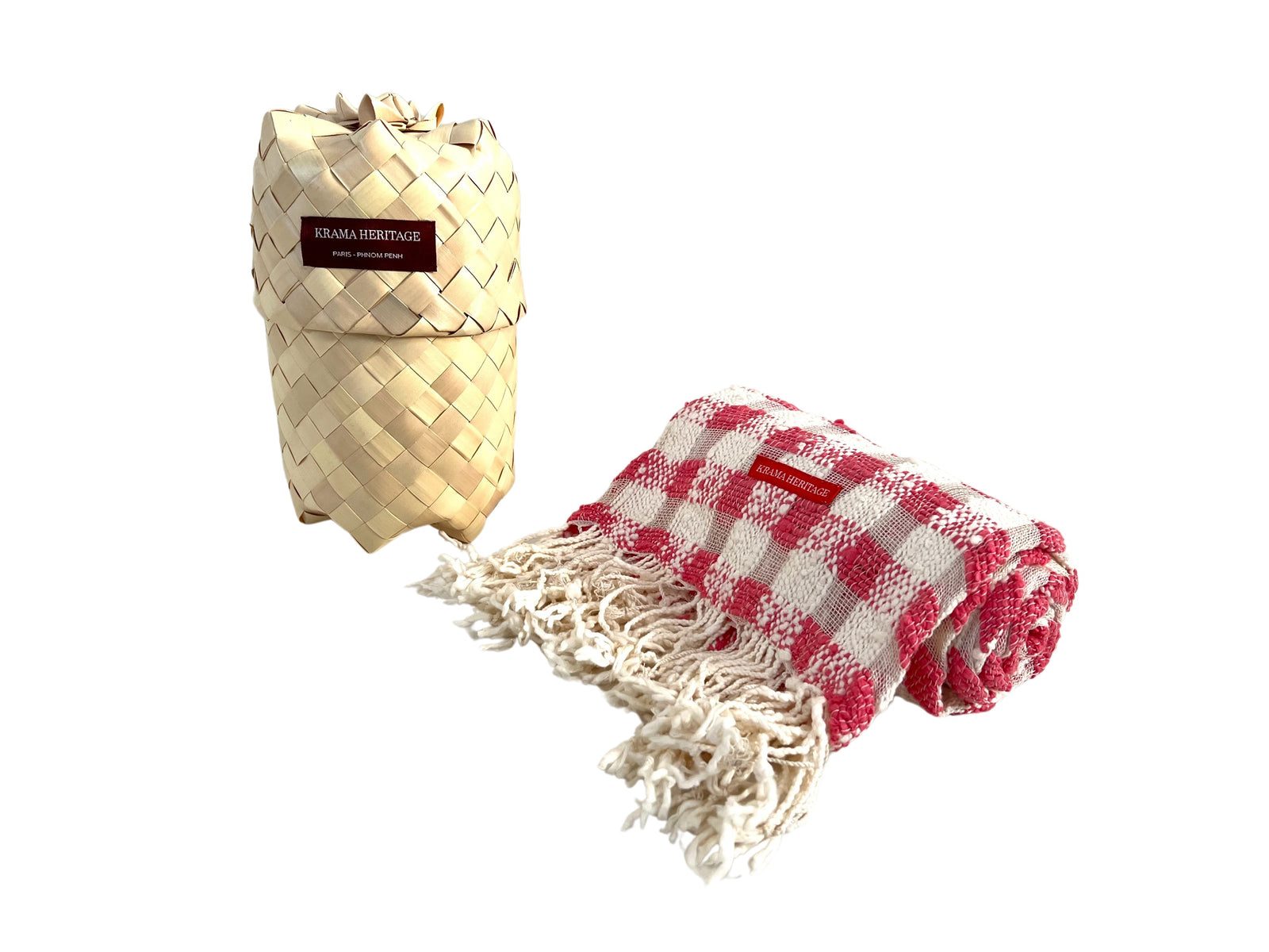 Krama Naturel à carreaux cerise et écru, posé devant son écrin tressé en feuille de palmier.