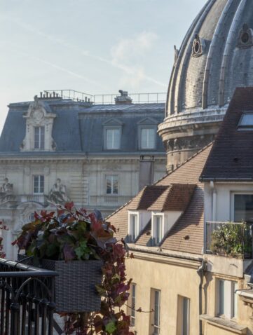 Balcon fleuri du Burgundy Paris face aux toits et au dôme de Notre-Dame-de-l'Assomption