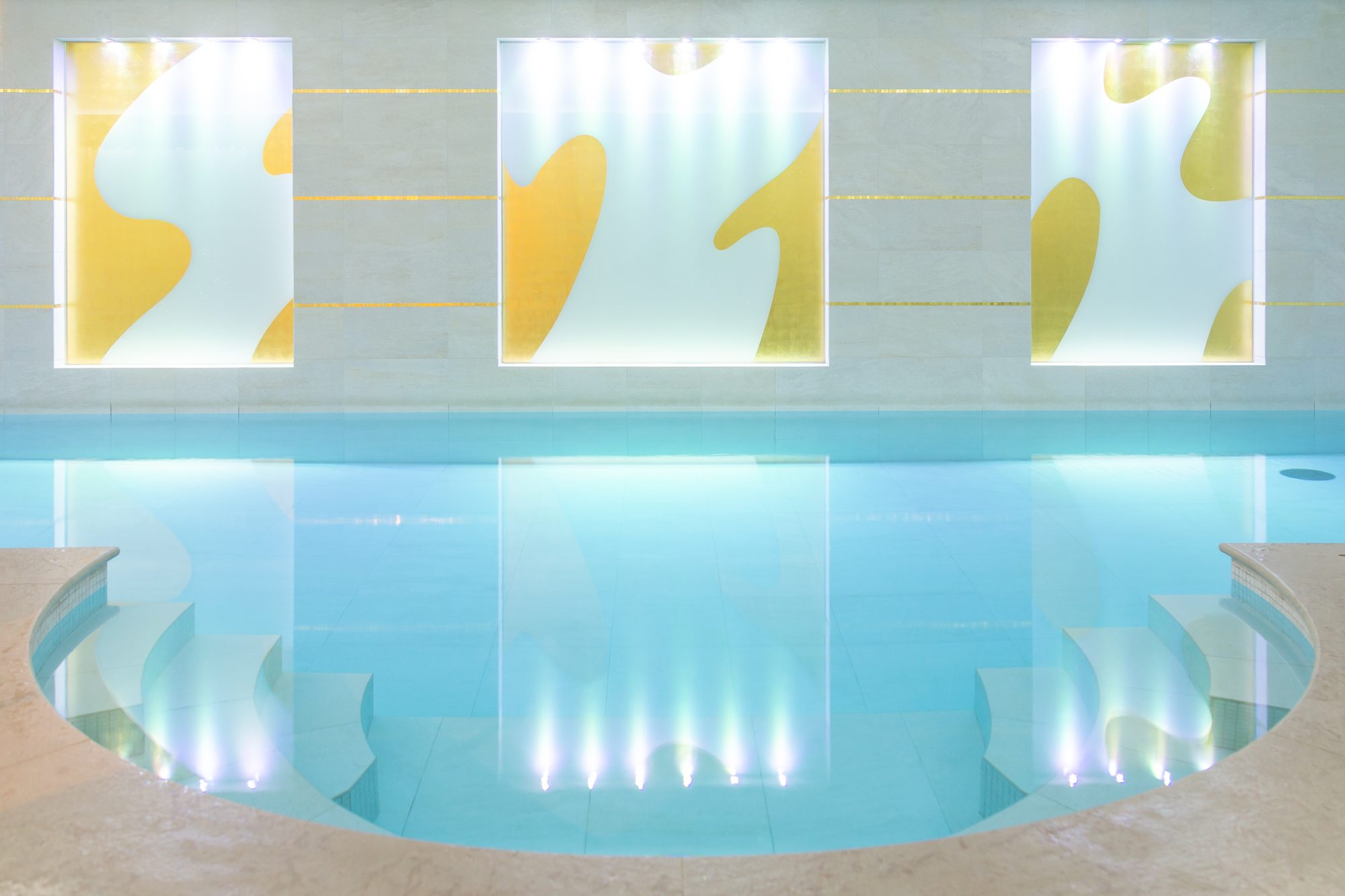 Piscine intérieure du spa du Burgundy Paris, bordée de panneaux dorés