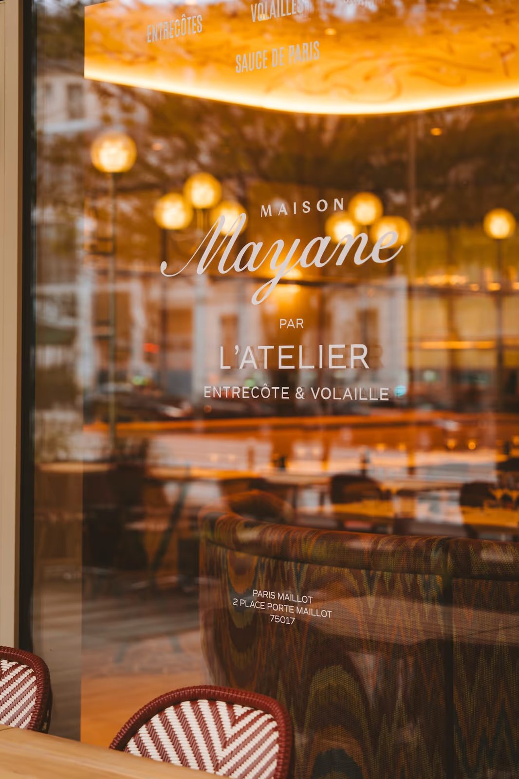 Vitrine de Maison Mayane par L'Atelier Entrecôte & Volaille à Porte Maillot, salle éclairée en arrière-plan.