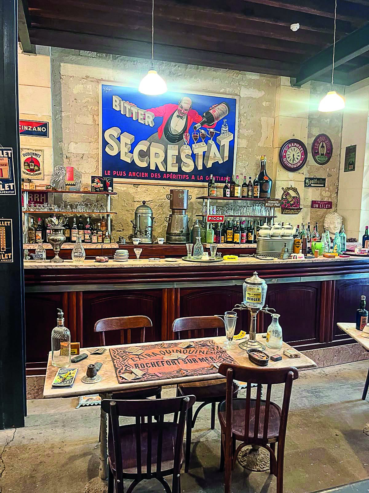 Bistrot du début du XXe siècle reconstitué, avec comptoir, affiche Secrestat et tables en bois